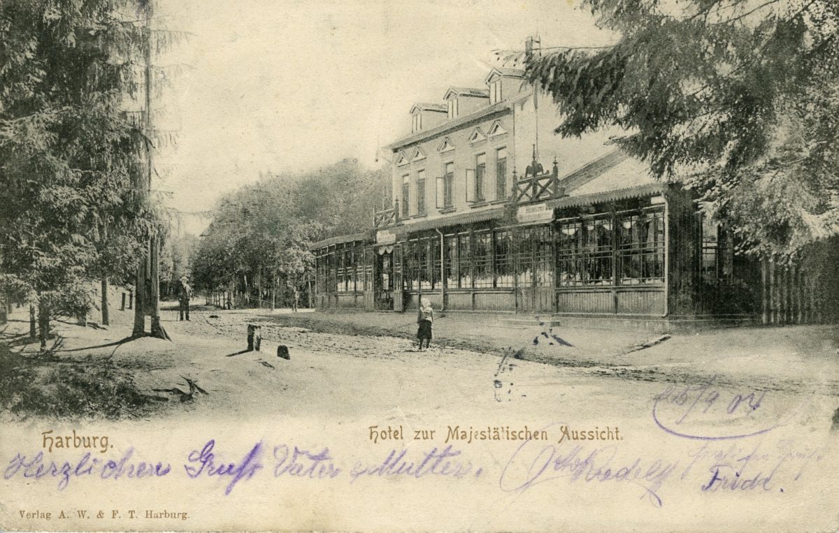 Postkarte mit historischen Foto des Lokals zur Majestätischen Aussicht: ein zweistöckiges Gebäude mit langer Glasfront am einem breiten Sandweg