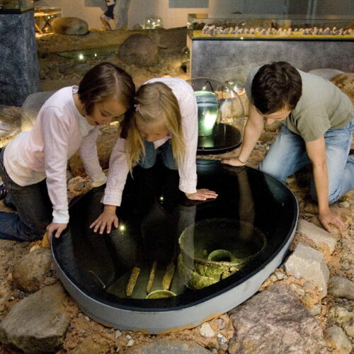 Kinde entdecken in der Ausstellung Exponate aus der Römerzeit.