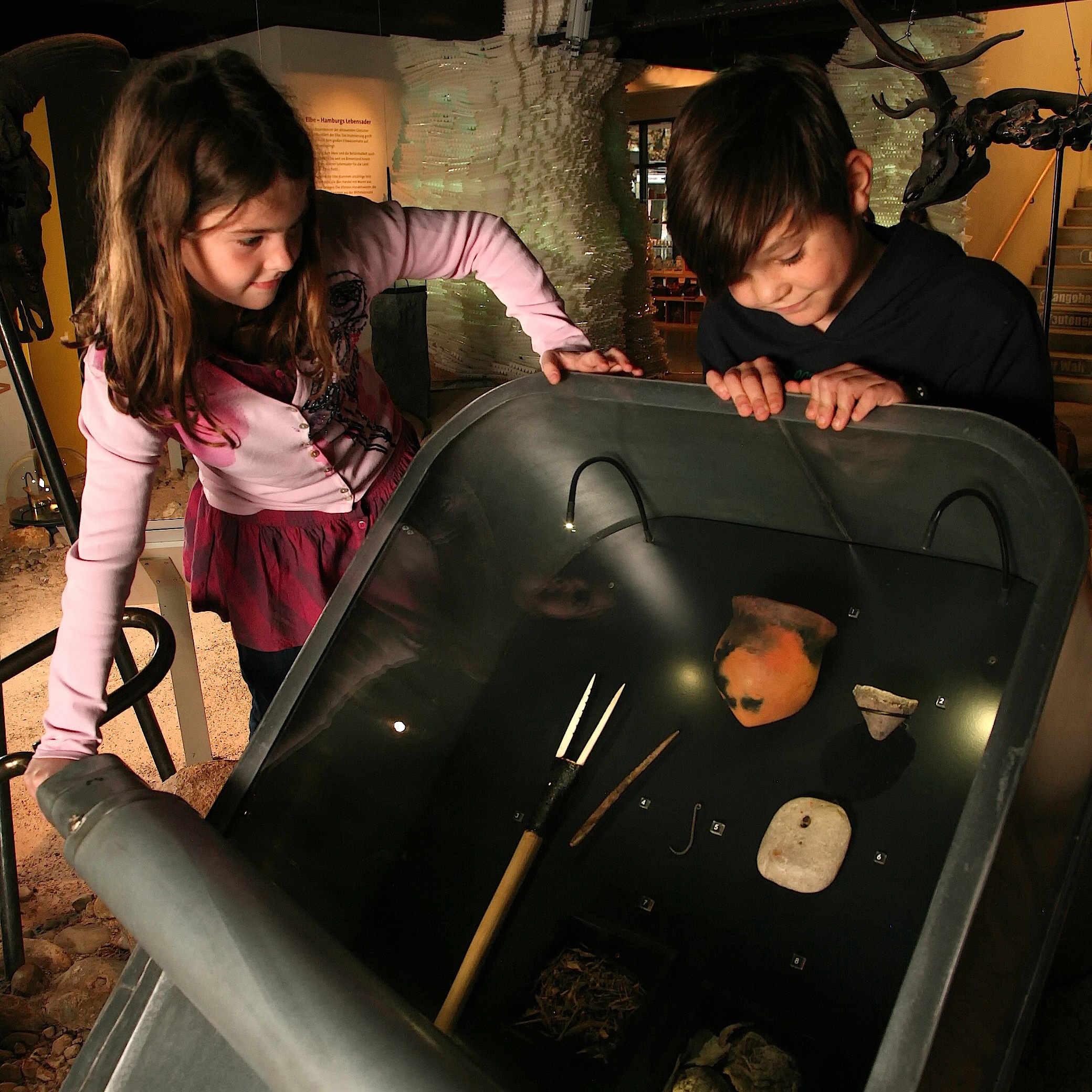 Kinder entdecken archäologische Funde in der Ausstellung.