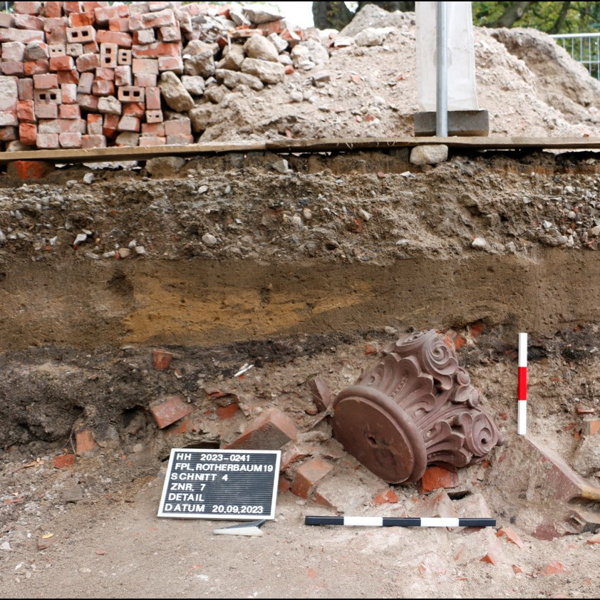 Das Foto zeigt eine Ausgrabungssituation: ein freigelegtes Säulenfragment der Synagoge,