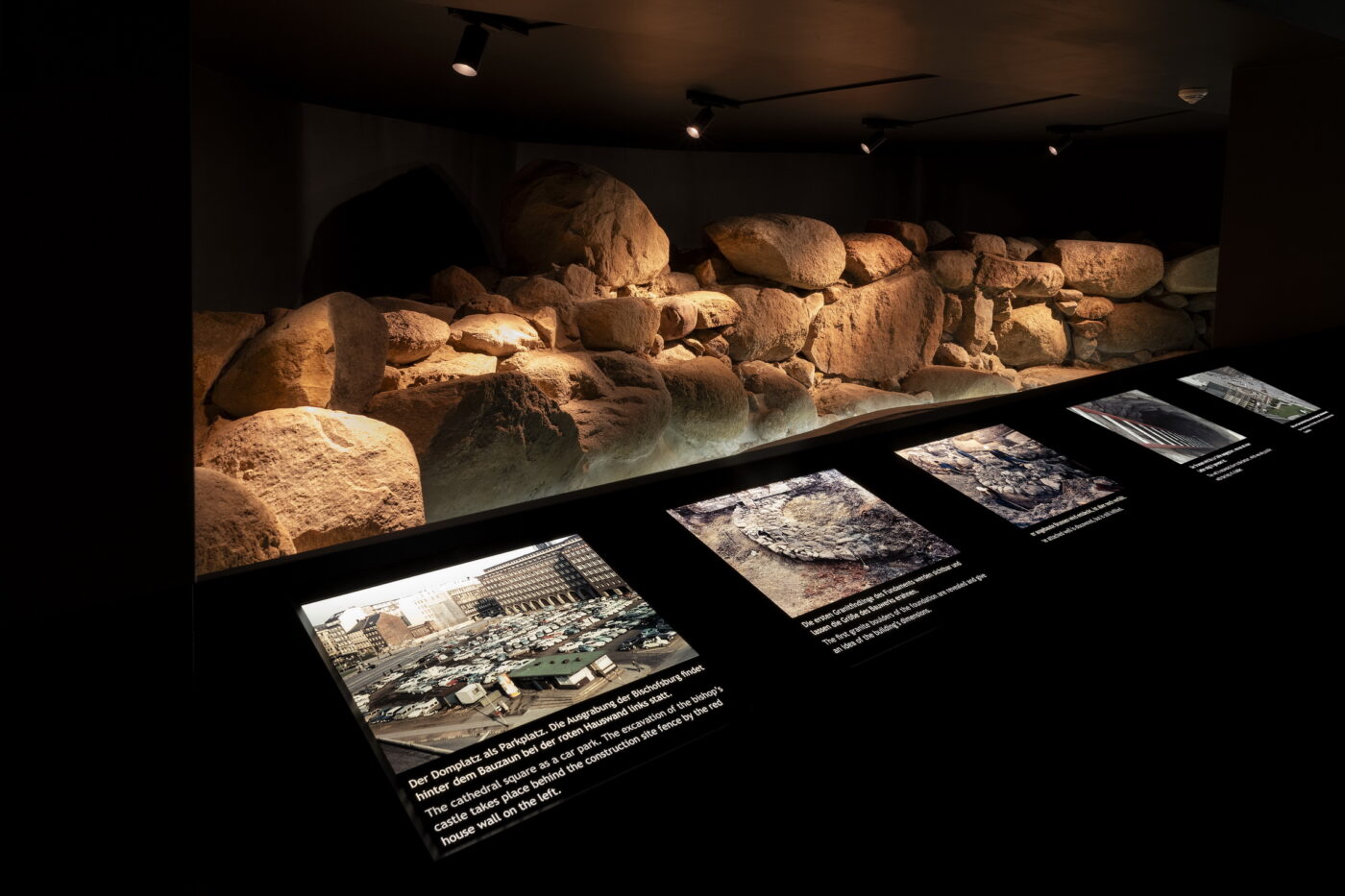 In der Ausstellung sind neben dem Steinfundament historische Fotografien des Domplatzes und der Ausgrabungen zu sehen