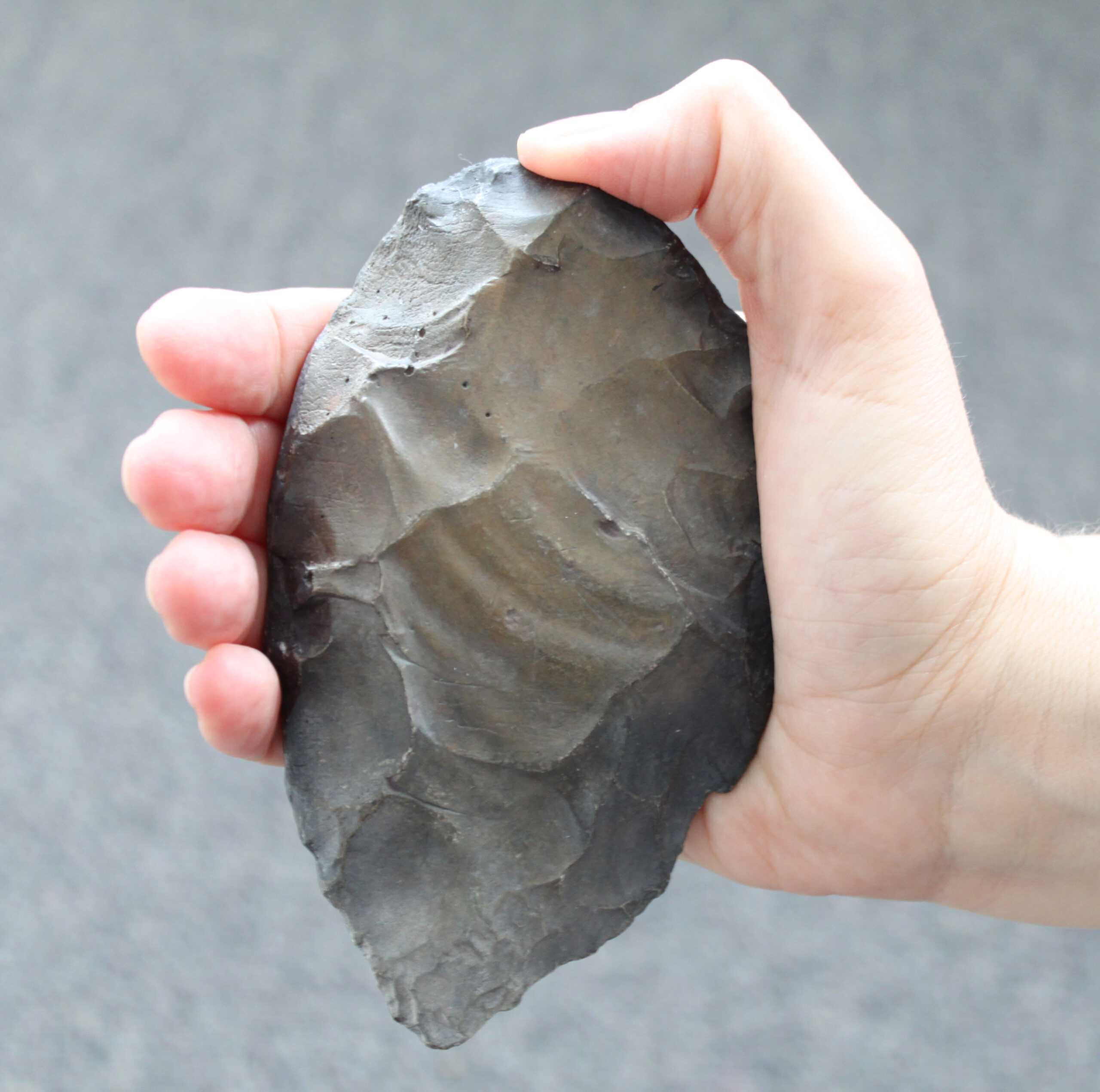 Faustkeil aus Feuerstein in Handhabung.