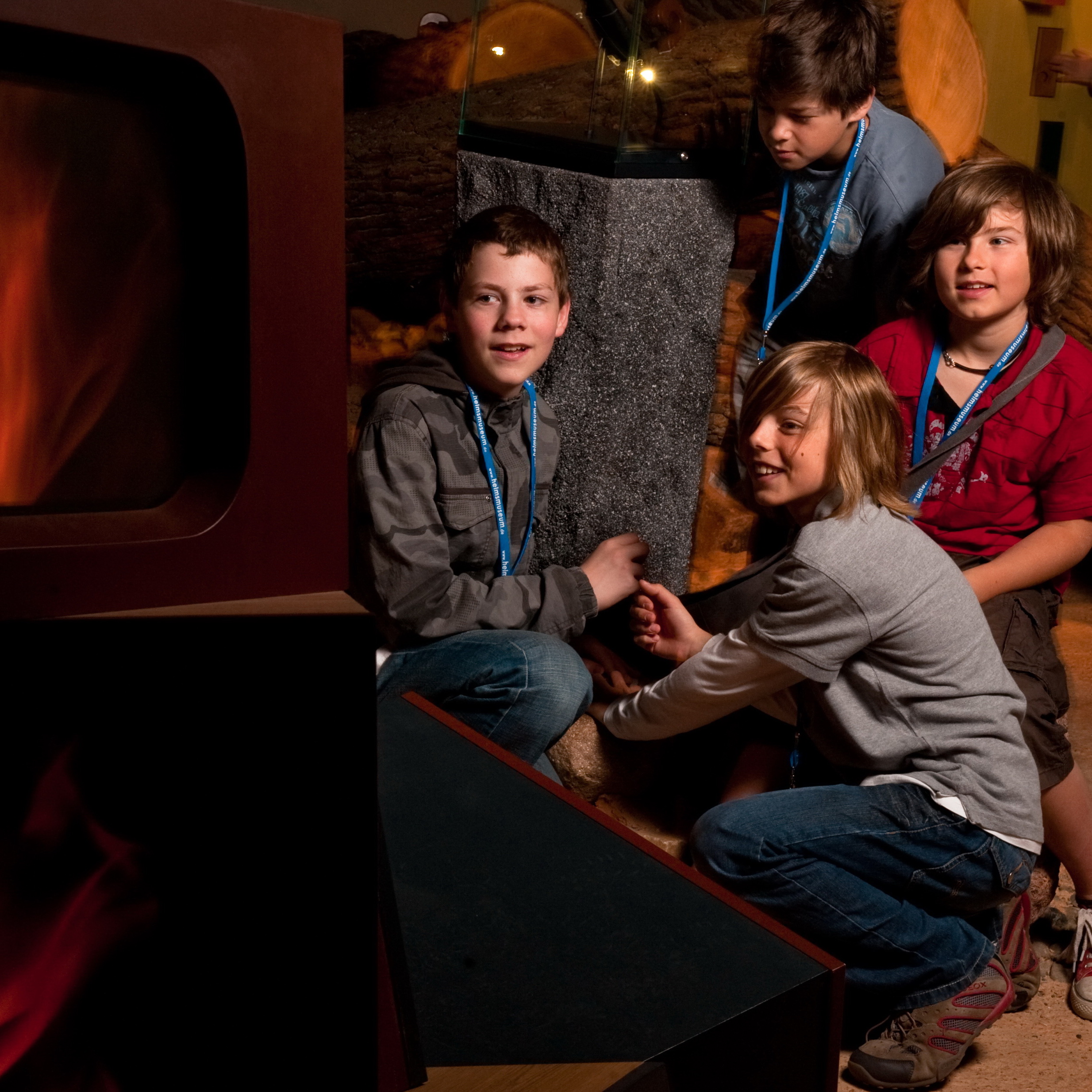 Kinder betrachten die Inszenierung einer Feuerstelle in der Ausstellung.